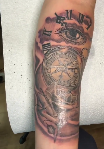 Tattoo of a compass that has an eye on top of it